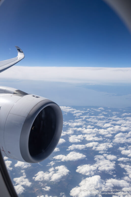 an airplane wing and engine above clouds