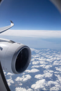 an airplane wing and engine above clouds