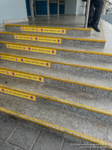 a person walking up stairs with yellow warning signs