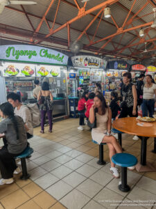 people sitting at tables in a food court