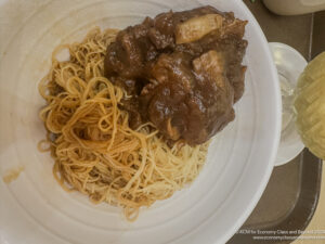 a plate of noodles and meat