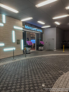 a hotel entrance with purple flowers