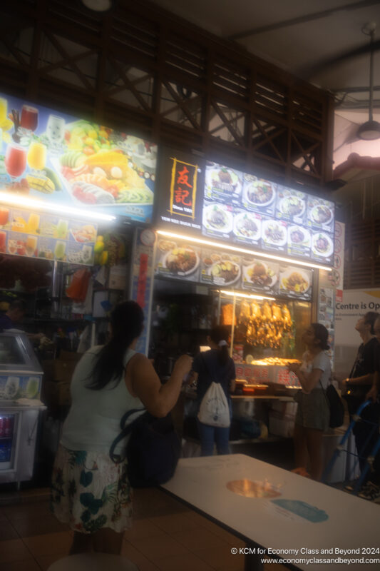 people standing in front of a food stand