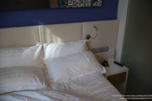 a bed with white pillows and a white headboard