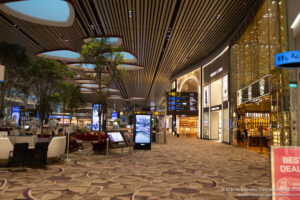 a large airport with many shops and a large screen