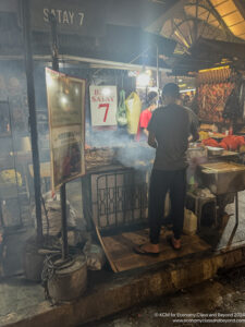 a man standing in front of a food stall