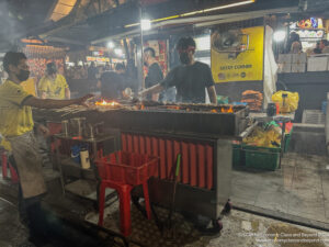 a man cooking food at a food stand