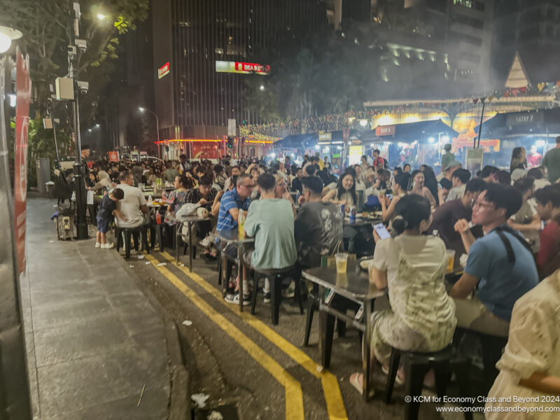 a group of people sitting at tables outside at night