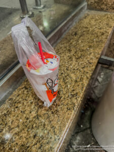 a plastic bag with a straw and a cup on a counter