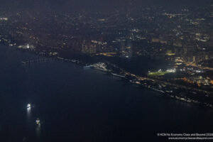 a city at night with lights on the water