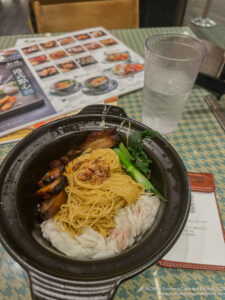 a bowl of noodles and meat on a table