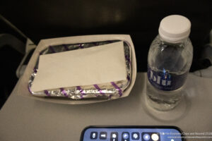a food in a container next to a bottle of water