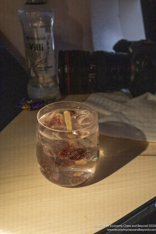 a glass of water with ice and a straw