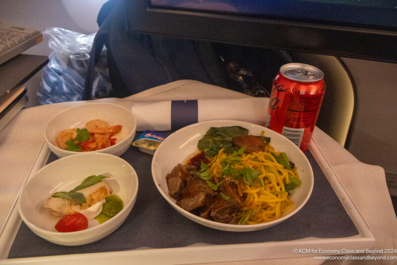 a plate of food and a can of soda