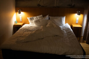 a bed with white sheets and pillows