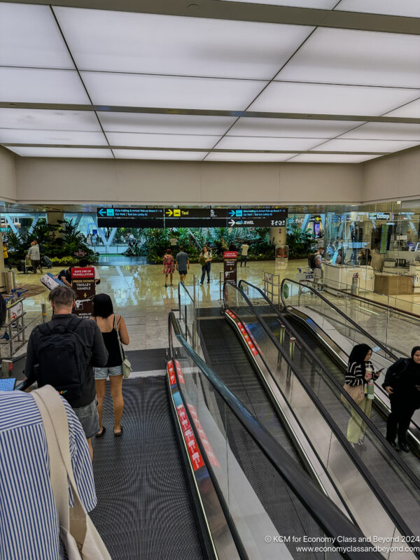 a group of people walking down an escalator