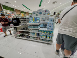 a man walking past a store with a shelf of items