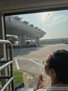 a woman looking out a window at a road