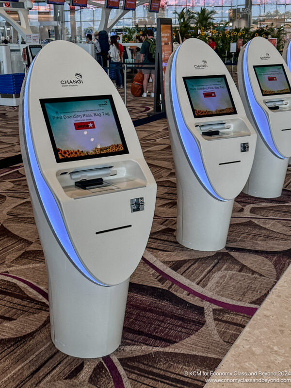 a group of white kiosks on a carpeted floor