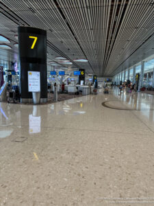 a large airport terminal with signs and people walking