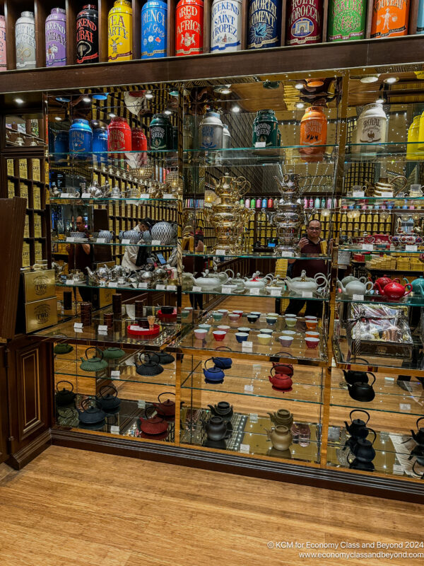 a glass display case with many teapots and other objects