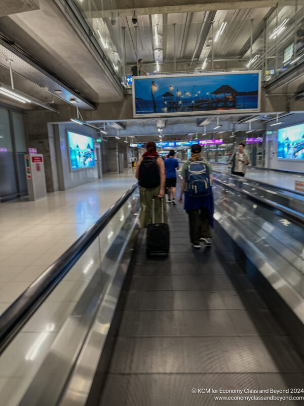 people walking on a moving walkway