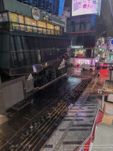 a street with cars and buildings in the rain