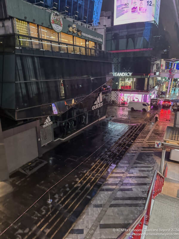 a street with cars and buildings in the rain