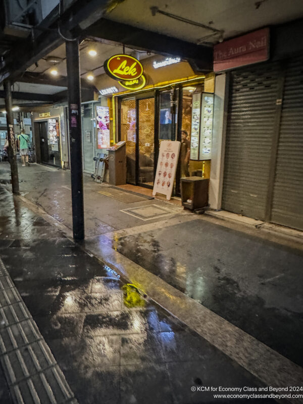 a wet street with a storefront