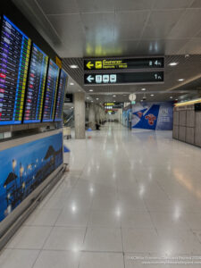 a large airport terminal with signs and information boards
