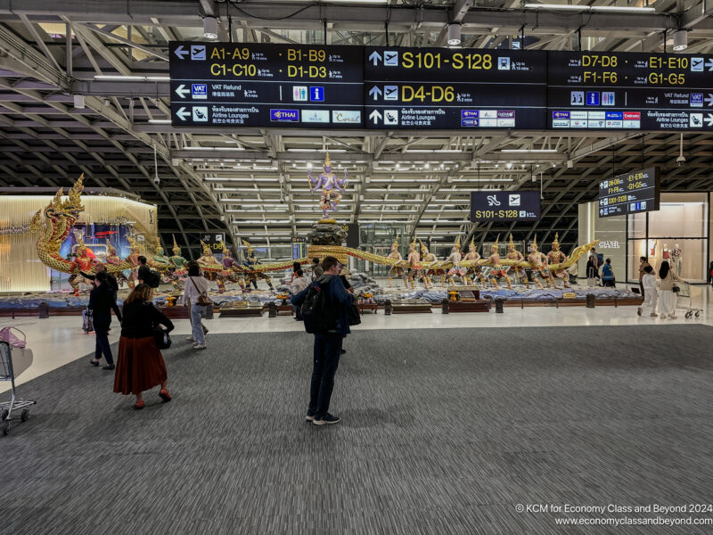 people in an airport with a large display of signs