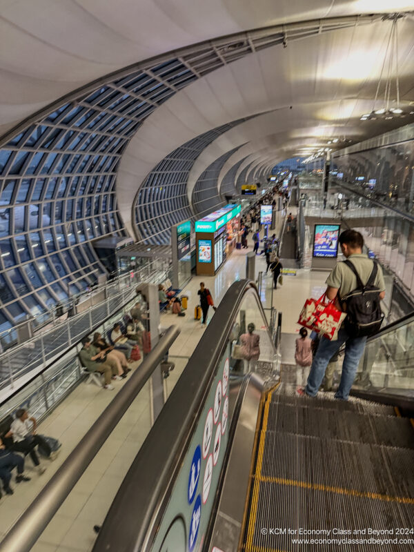 people on an escalator in a terminal