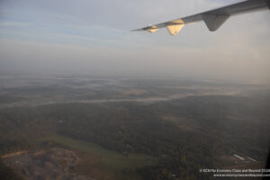 an airplane wing above a landscape