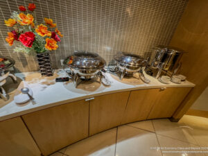 a buffet with a group of silver containers on a counter