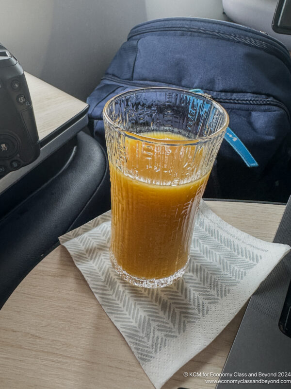 a glass of orange juice on a napkin