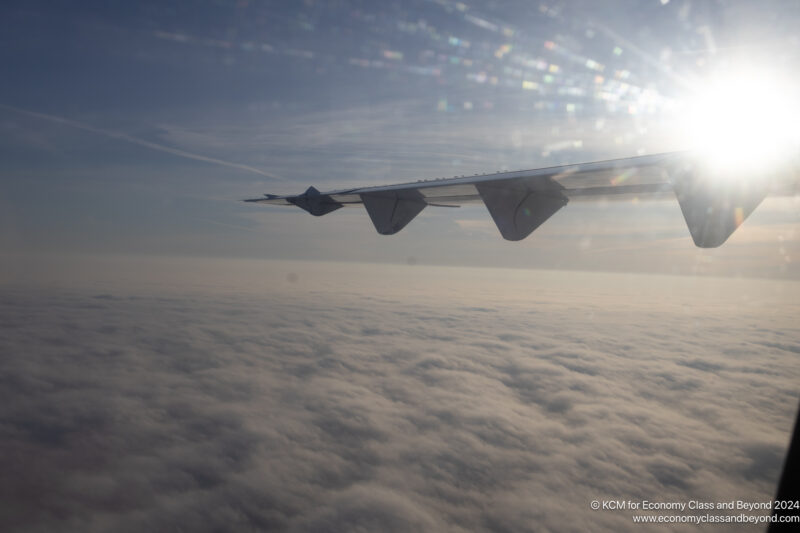 wing of an airplane flying above clouds