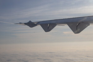 the wing of an airplane flying above clouds