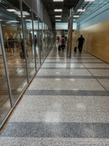 a hallway with glass walls and people walking