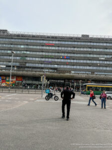 a man standing in front of a large building