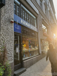 a woman walking down a sidewalk in front of a store