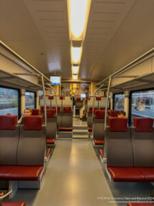 a train with red seats and a couple of people