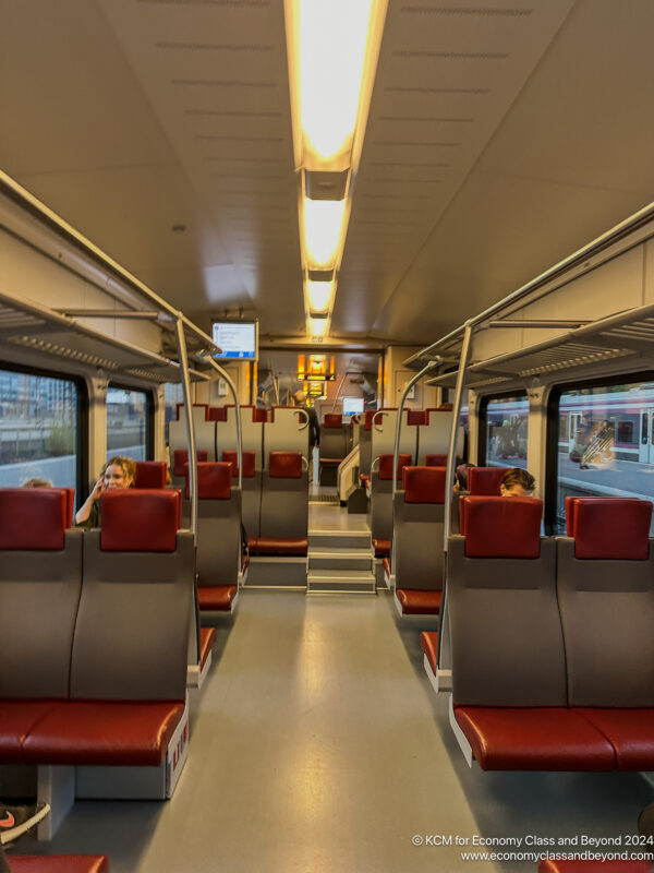 a train with red seats and a couple of people