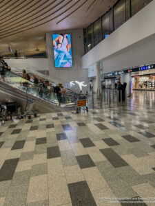 a group of people on an escalator in a large airport