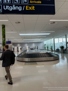 a man walking in a large airport terminal with luggage carousel