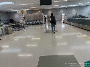 a woman walking in a large room with luggage conveyor belts