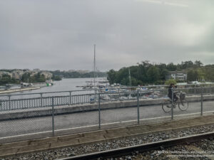 a person riding a bicycle on a bridge over a river