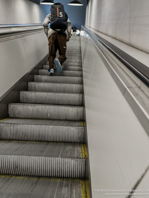 a person walking up an escalator