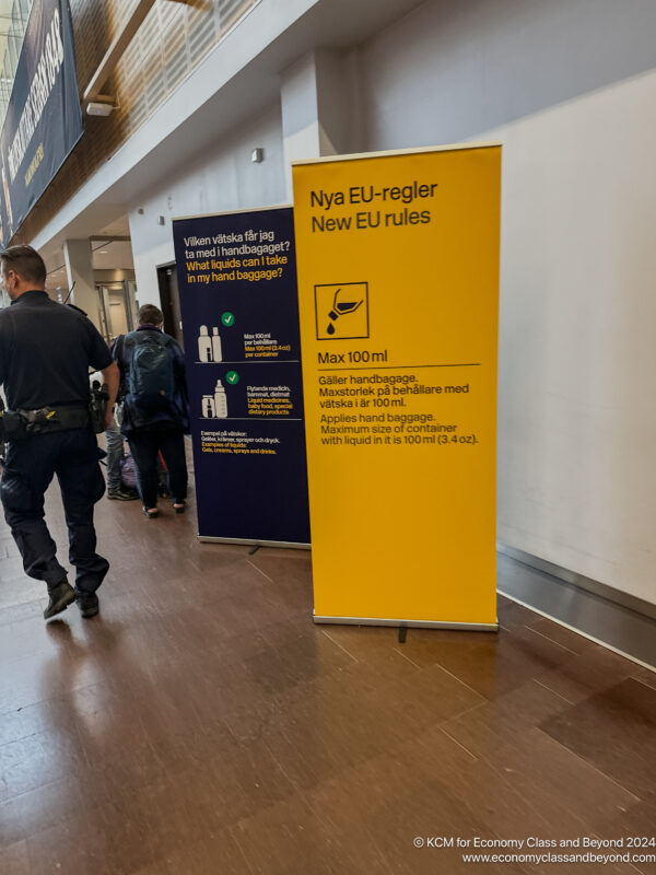 a man walking in a hallway with a yellow sign