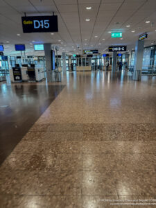 a large airport terminal with signs and people