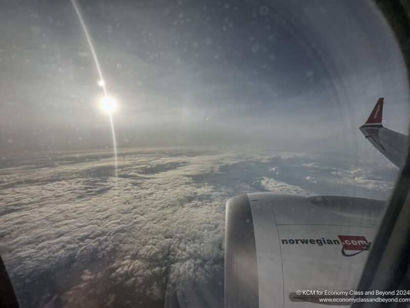 a view of clouds and the sun from an airplane window